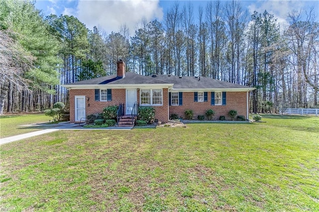 ranch-style home with a chimney, brick siding, and a front lawn
