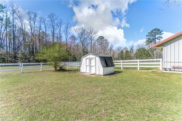 view of yard with a fenced backyard, an outbuilding, and a storage shed