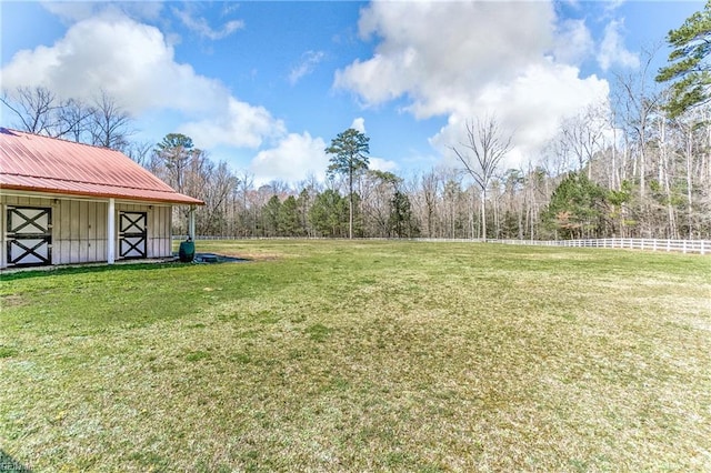 view of yard with an exterior structure, an outbuilding, and a forest view