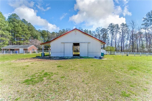 view of pole building featuring fence and a yard