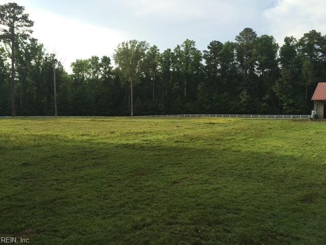view of yard with fence and a rural view