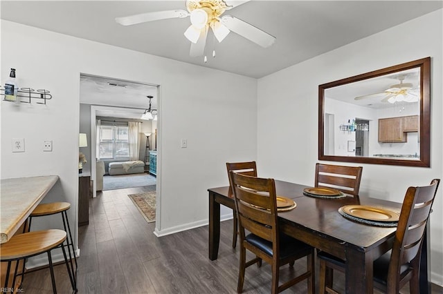 dining room featuring a ceiling fan, dark wood-style flooring, and baseboards