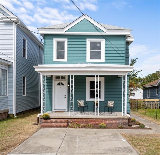american foursquare style home with a porch and fence