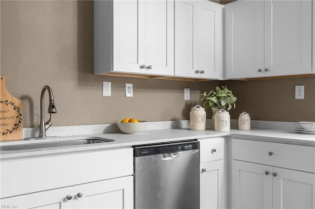 kitchen with dishwasher, white cabinetry, light countertops, and a sink