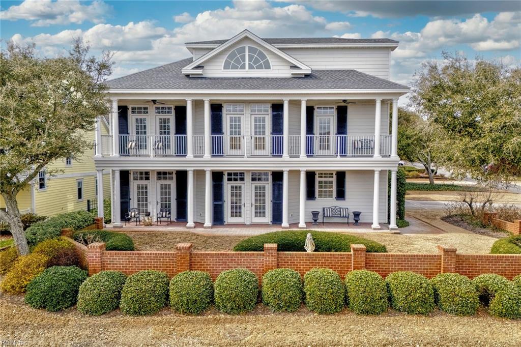greek revival house with a balcony, french doors, and ceiling fan