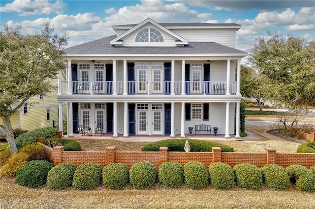 greek revival house with a balcony, french doors, and ceiling fan