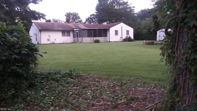 view of yard featuring a storage shed, an outdoor structure, and a sunroom