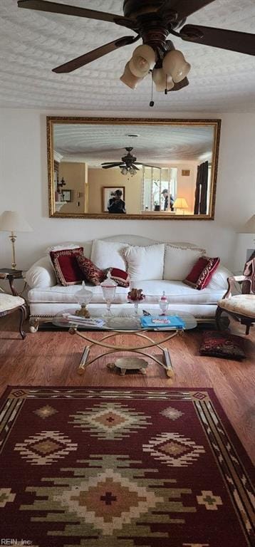 living room featuring wood finished floors, a textured ceiling, and ceiling fan