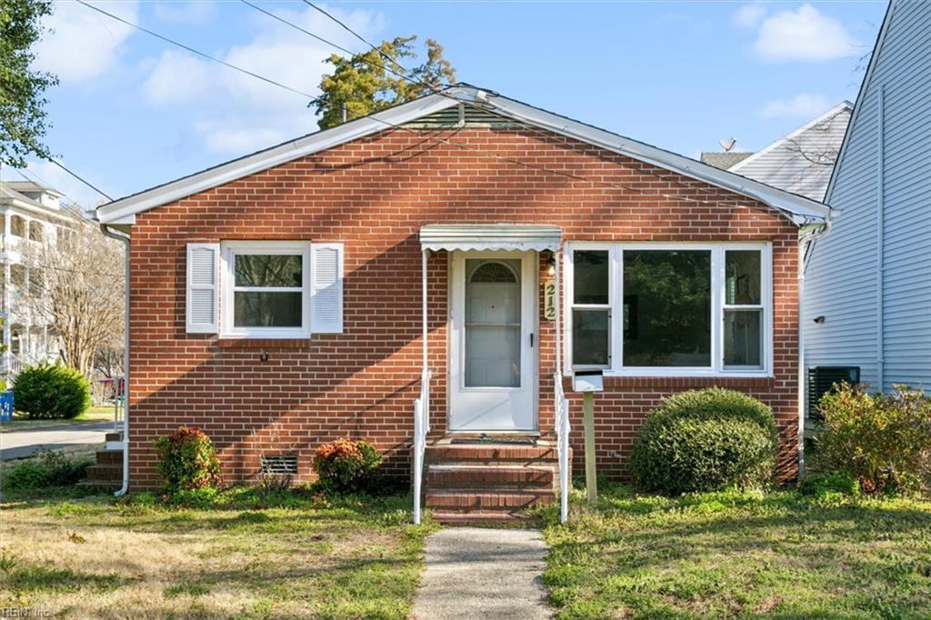 bungalow-style home with brick siding, a front yard, and entry steps