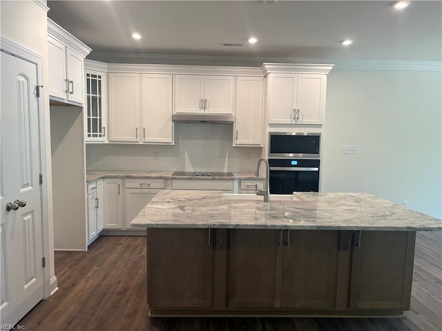 2050 Swiss Ln, Hayes, VA 23072 - kitchen with appliances with stainless steel finishes, under cabinet range hood, white cabinetry, a center island with sink, and dark wood-style flooring