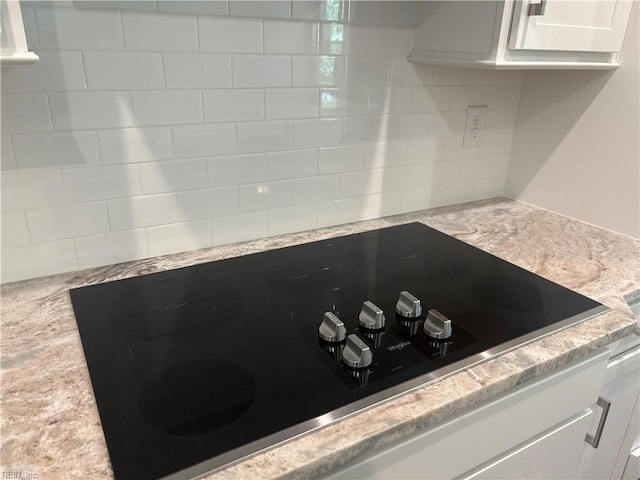 2050 Swiss Ln, Hayes, VA 23072 - kitchen view of black electric stovetop, backsplash, white cabinets, and light stone counters