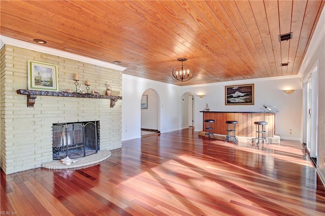 living room with wood finished floors, visible vents, arched walkways, crown molding, and wooden ceiling