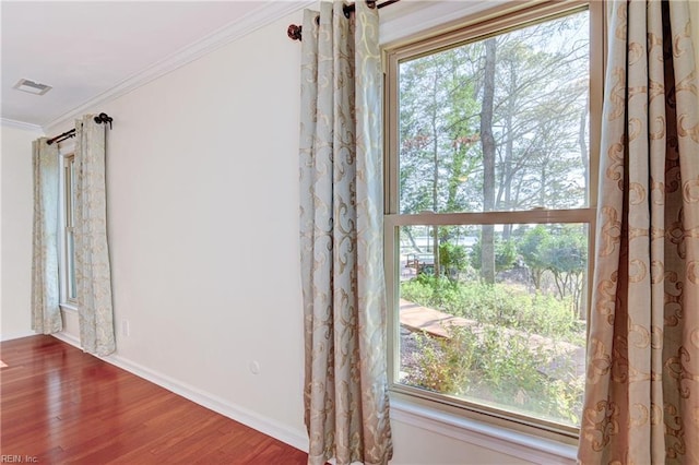 interior details featuring visible vents, baseboards, wood finished floors, and crown molding