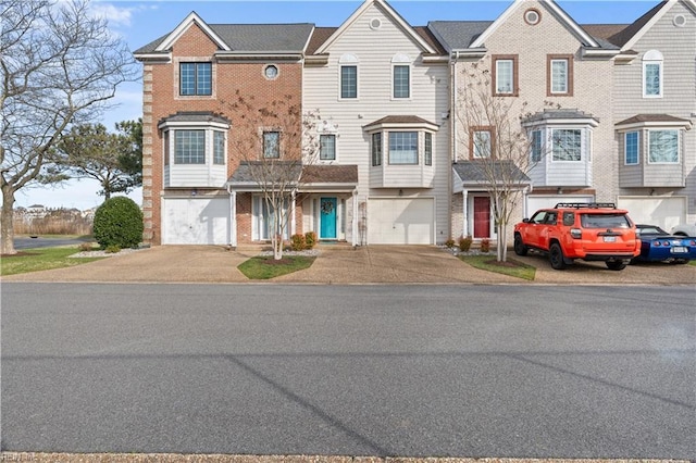 multi unit property featuring brick siding, a garage, and driveway