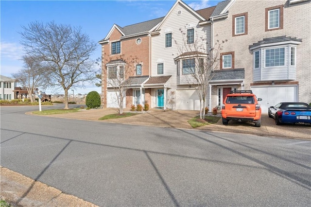 multi unit property featuring a residential view, driveway, and an attached garage