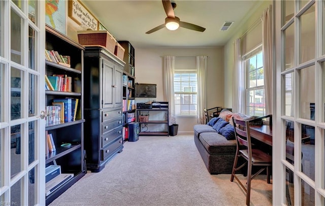 home office featuring a ceiling fan, light colored carpet, visible vents, and french doors