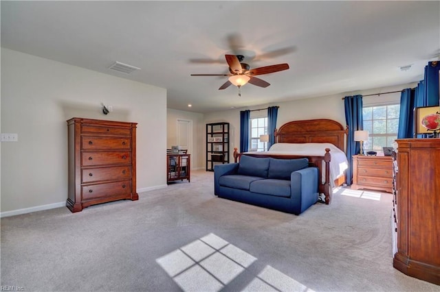 bedroom with visible vents, multiple windows, baseboards, and light carpet