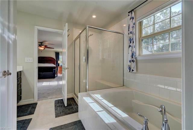 bathroom with ensuite bath, a bath, a healthy amount of sunlight, and a stall shower