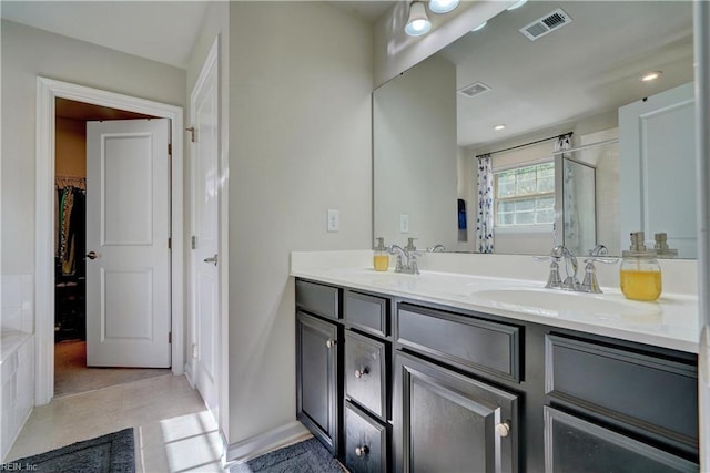 full bath with double vanity, visible vents, a shower stall, and a sink