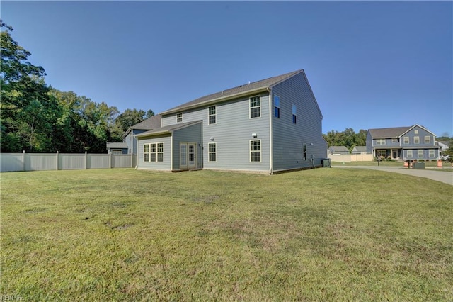 back of house featuring a yard, fence, and central AC