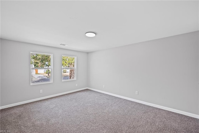 carpeted spare room featuring visible vents and baseboards