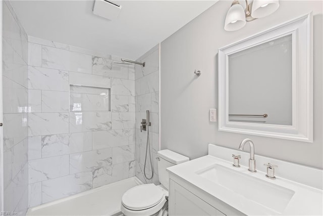 bathroom with vanity, toilet, and tiled shower