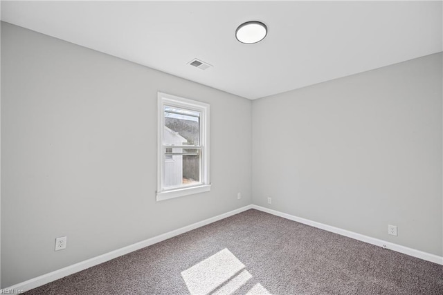 carpeted spare room featuring visible vents and baseboards