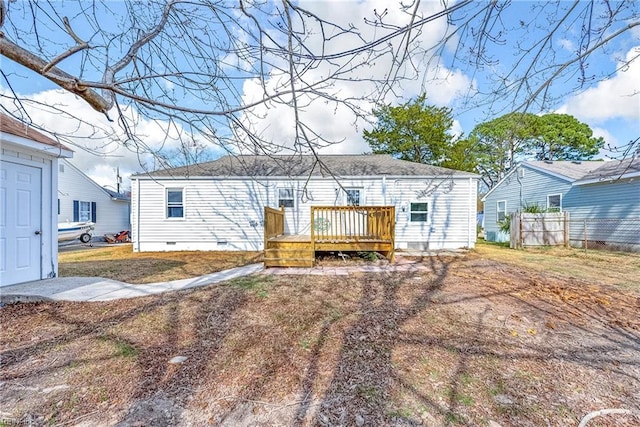 rear view of property featuring a wooden deck, fence, and crawl space