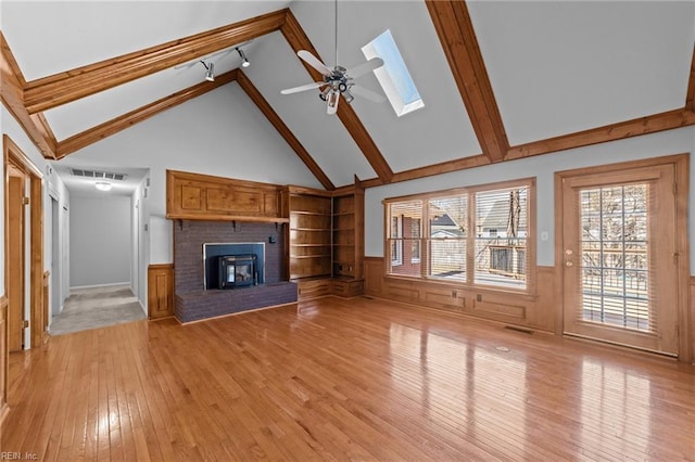 4825 Berrywood Rd, Virginia Beach, VA 23464 - unfurnished living room featuring a skylight, light wood-type flooring, visible vents, ceiling fan, and wainscoting