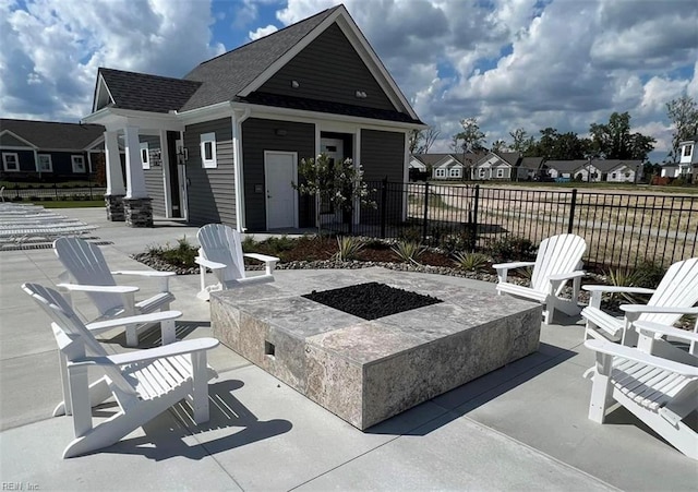 view of patio / terrace featuring an outdoor fire pit, fence, and a residential view