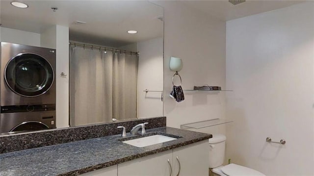 full bath with toilet, stacked washer and dryer, recessed lighting, and vanity