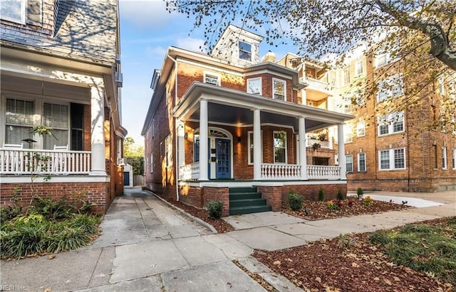 view of front of house with covered porch and brick siding