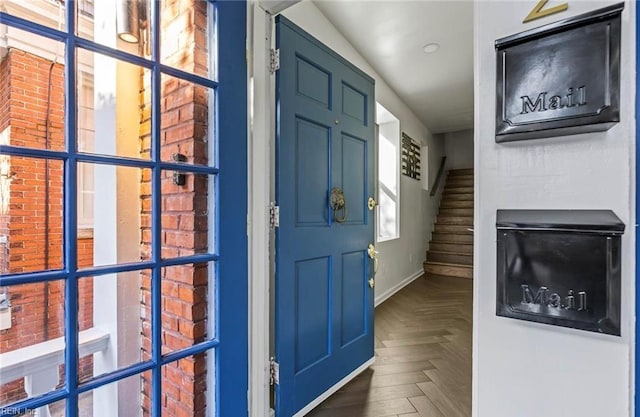 foyer entrance featuring baseboards and stairway
