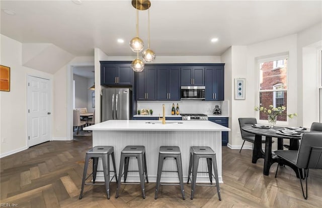 kitchen with light countertops, a breakfast bar, a sink, and stainless steel appliances