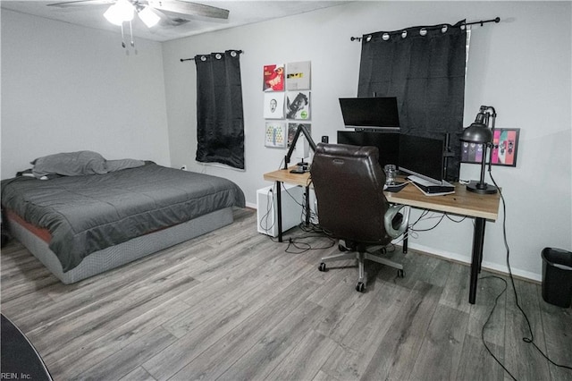 bedroom featuring baseboards, a ceiling fan, and wood finished floors