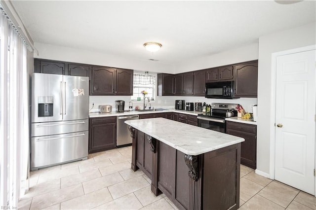 kitchen featuring a center island, dark brown cabinets, light tile patterned flooring, a sink, and stainless steel appliances