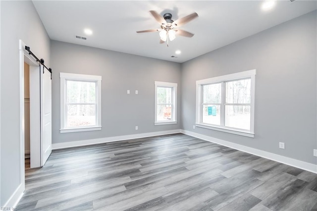 11AC Glass Rd, Hayes, VA 23072 - unfurnished bedroom featuring a barn door, baseboards, visible vents, and dark wood-style flooring