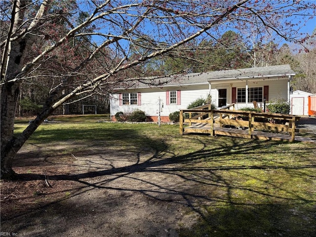 ranch-style house with a storage unit, a front lawn, and an outdoor structure