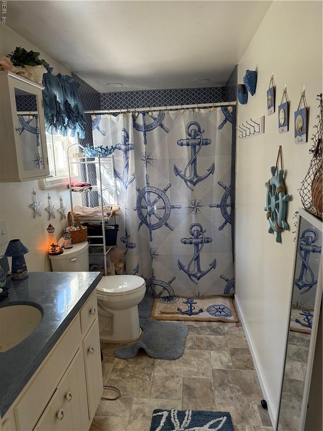 full bath with vanity, toilet, stone finish floor, and a shower with curtain