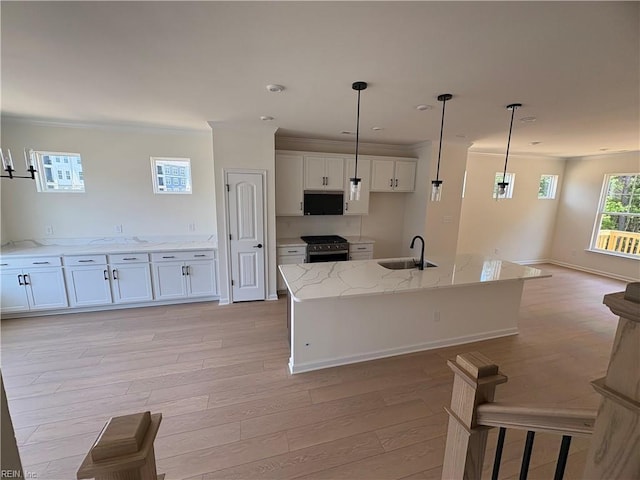2014 Stanford Ln, Newport News, VA 23608 - kitchen featuring stainless steel gas range, light wood-type flooring, open floor plan, a sink, and white cabinets