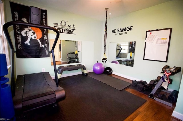 workout room featuring baseboards and wood finished floors