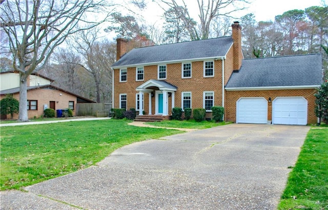 colonial inspired home with a front yard, driveway, an attached garage, and a chimney