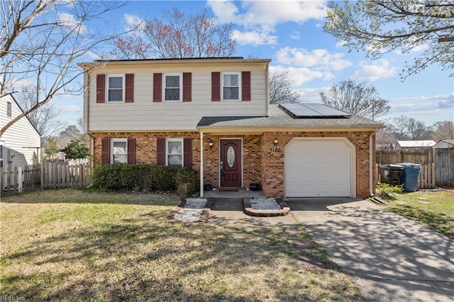 view of front of house with an attached garage, driveway, a front lawn, brick siding, and roof mounted solar panels