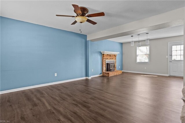 unfurnished living room featuring baseboards, a fireplace, ceiling fan, and dark wood-style flooring