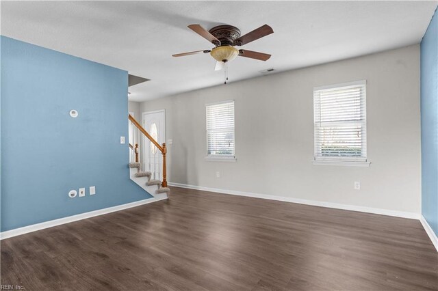 empty room with stairs, a wealth of natural light, ceiling fan, and visible vents