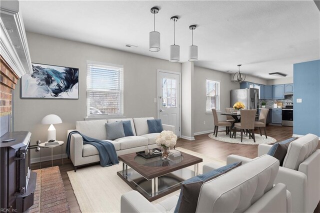 living area with baseboards, visible vents, and light wood-type flooring