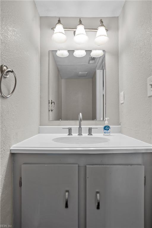 bathroom with vanity and a textured wall