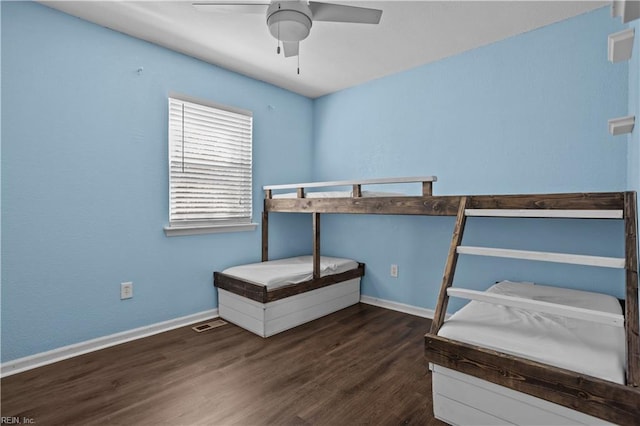 unfurnished bedroom featuring baseboards, visible vents, wood finished floors, and ceiling fan