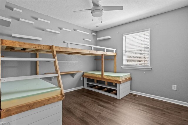 bedroom featuring baseboards, a textured ceiling, and wood finished floors