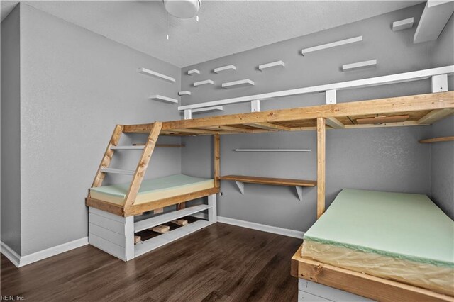 unfurnished bedroom with baseboards, a textured ceiling, and wood finished floors